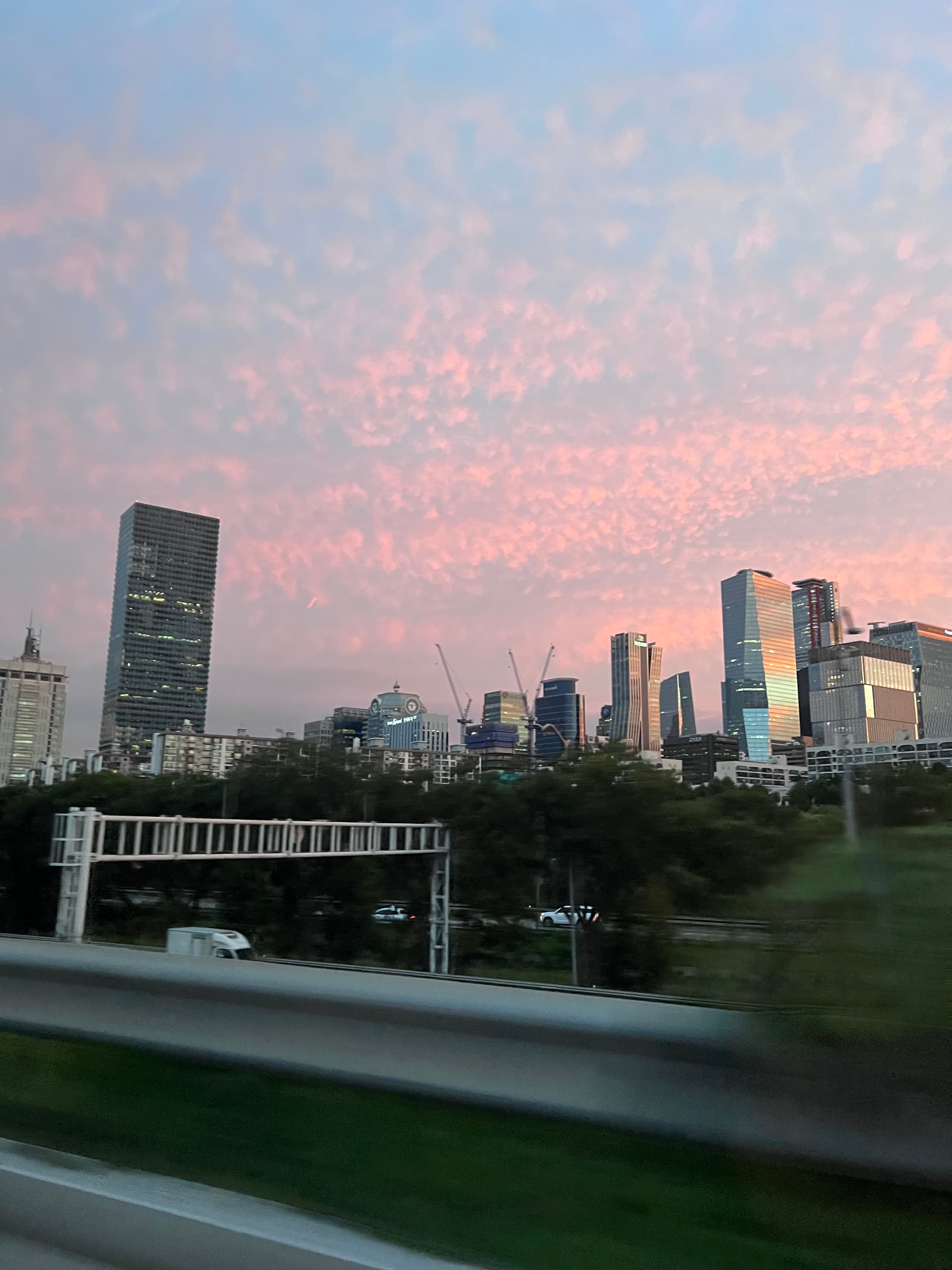 Seoul skyline beneath a broad pink and blue evening sky